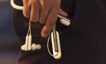 man's hand holding earphones