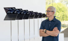 Apple CEO Tim Cook standing next to a line of MacBook Airs at an Apple store