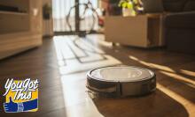 robot vacuum in living room with coach, balcony, and bike