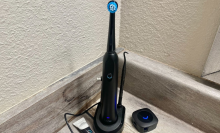 electric toothbrush on charging stand in the corner of a bathroom counter