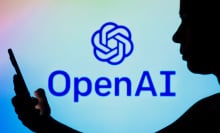 a mobile phone user in front of the OpenAI logo