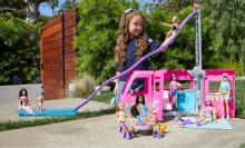 Little girl playing with Barbie Dream Camper 