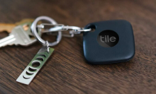Tile tracker attached to keychain on wooden surface