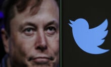 A photograph of Elon Musk is displayed on a computer screen behind the Twitter logo on a mobile phone.