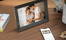 An image on a picture frame of a mother holding her baby and her husband.