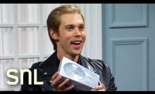 Austin Butler holding a grey catch-all ash tray