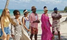 Six Black adults in beachwear on secluded beach