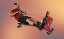 man in red shirt using rowing machine with colorful background