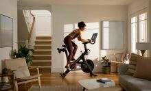 A lady is exercising on a fitness bike.