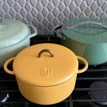 Three colorful Dutch ovens sitting on a stove