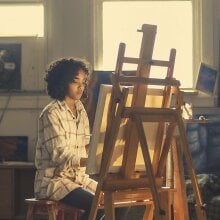 Person painting with an easel.
