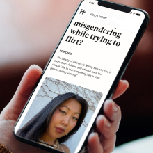 Hinge's new in-app educational guide for LGBTQ users is shown on a smartphone held in a hand.