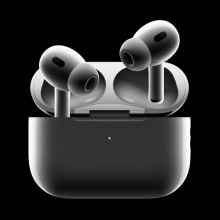 A pair of second-generation AirPods Pro with their charging case against a black background.
