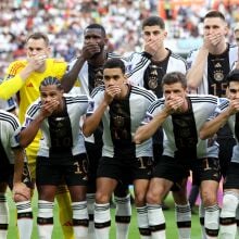 Germany players pose with their hands covering their mouths as they line up for the team photos.