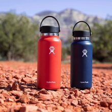 Two Hydro Flask water bottles in a desert landscape