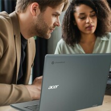 Man and woman sitting in front of gray Acer Spin 714 Chromebook