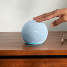 A person is touching the Echo Dot 5 smart speaker