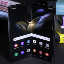 A Samsung Galaxy Z Fold4 is lying in front of a pile of books