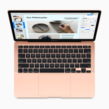 a top-down view of an open apple macbook air from late 2020 in gold