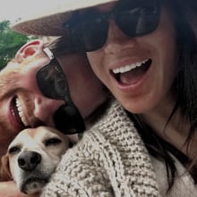 A couple take a selfie with their dog.