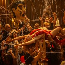 Margot Robbie body surfs in a decadent party scene in "Babylon."