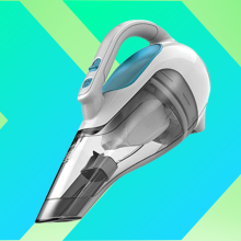 hand held vacuum at a 45 degree angle angle against a blue and green background