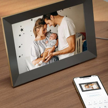 An image on a picture frame of a mother holding her baby and her husband.