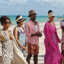 Six Black adults in beachwear on secluded beach