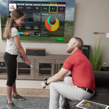 dad and daughter playing with the trugolf simulator