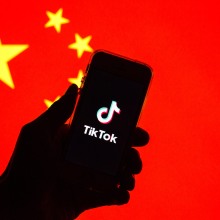 A phone with the TikTok logo in front of the Chinese flag
