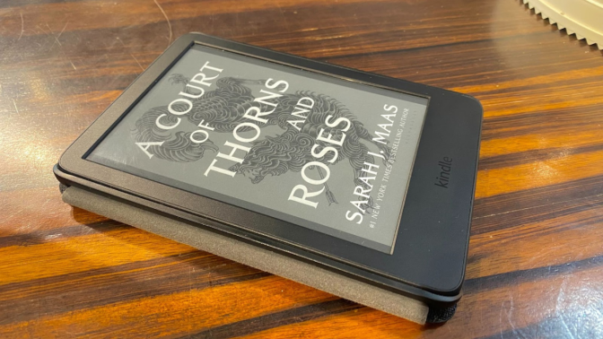 kindle with book cover sitting on table