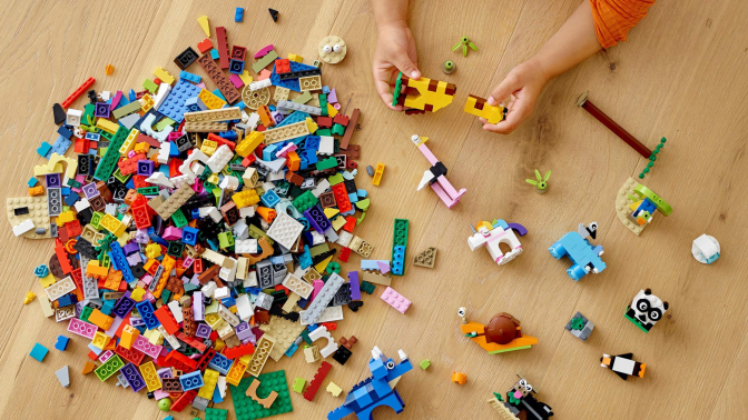 Aerial view of child playing with LEGOs on hardwood floor