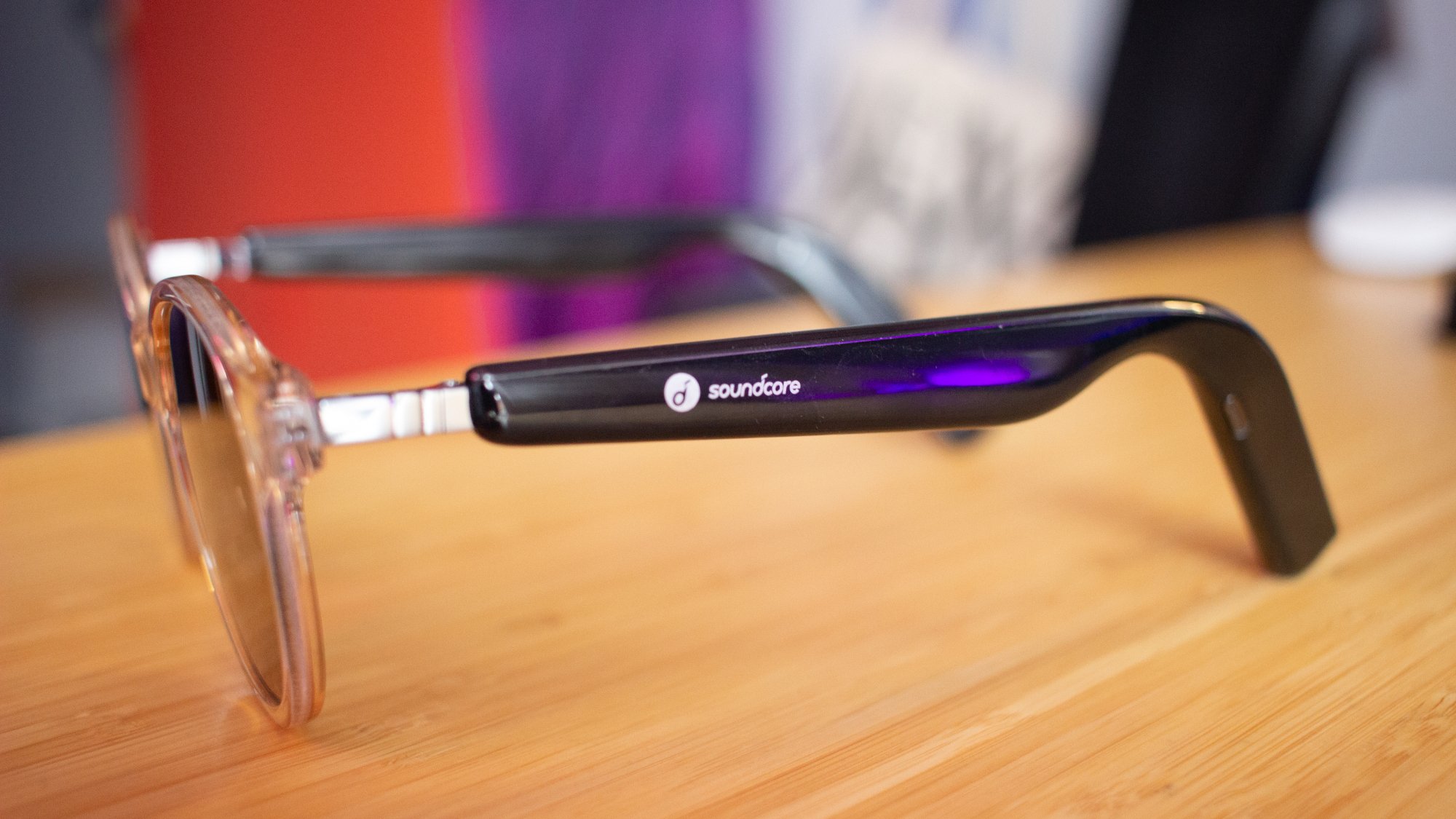 A pair of sunglasses open on a table viewed from the side