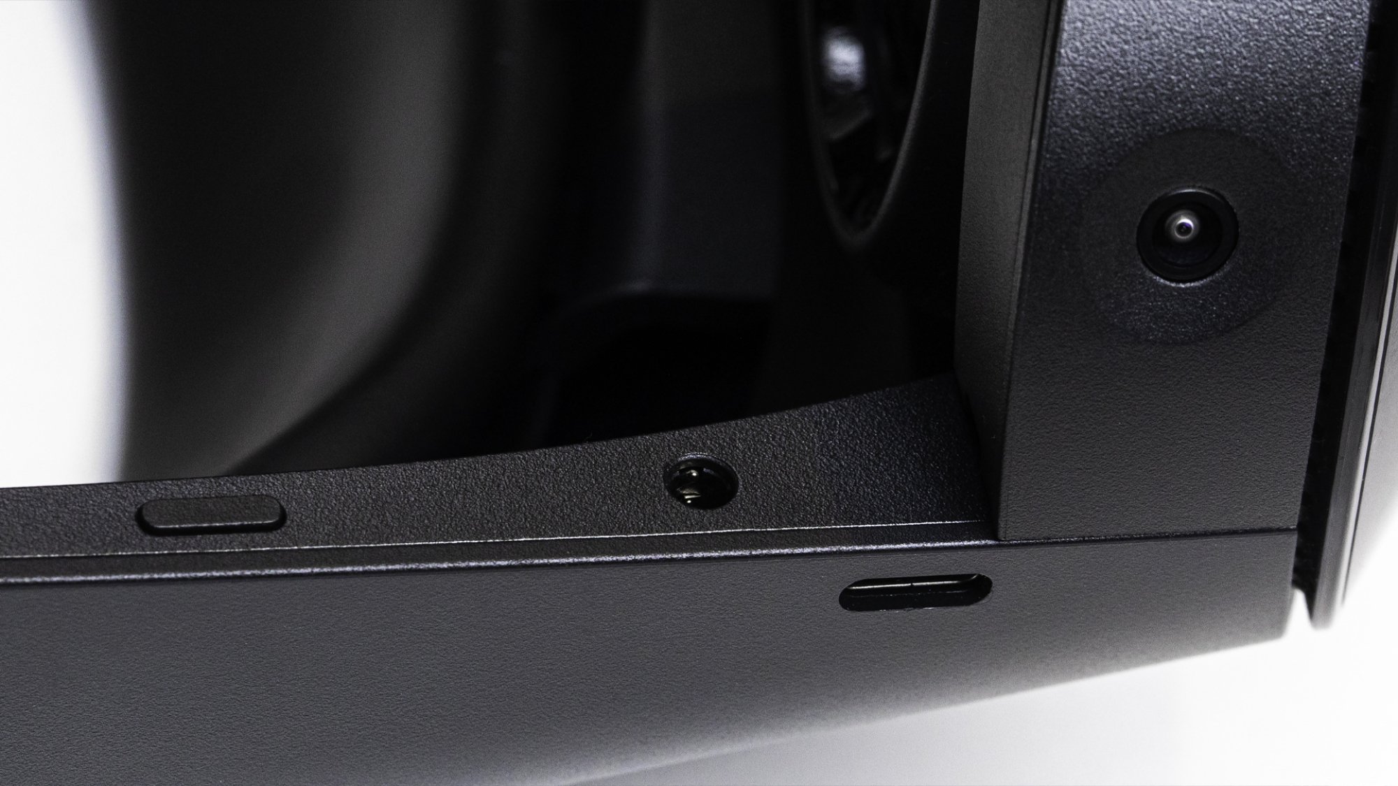 The underside of the left side of the headset which is matte black. A USB-C port, power button, and headphone jack are visible