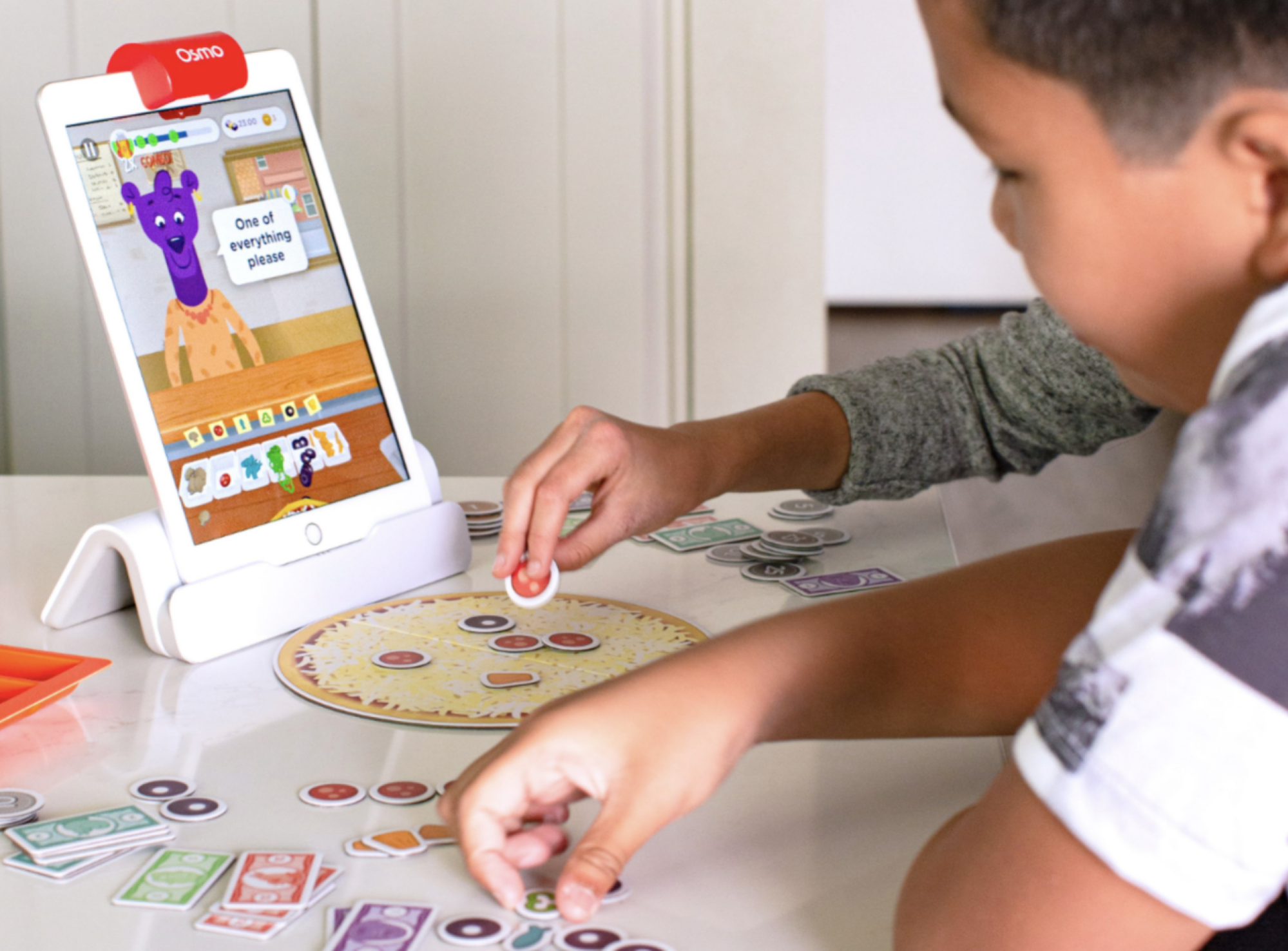 Child using tablet and playing with game pieces