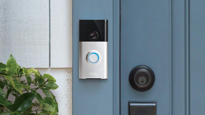 Black and silver rectangular doorbell camera attachment to blue door