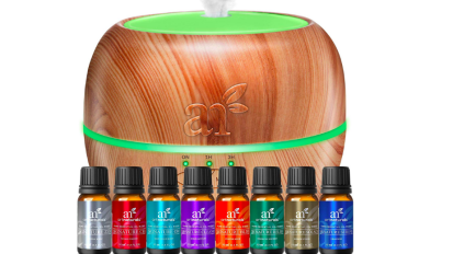 Round brown diffuser with green light and row of scented oils in front of it