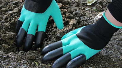 Black and cyan gardening gloves with pointed fingers digging into dirt