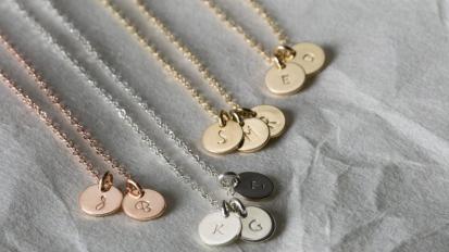 four necklaces with two circular pendants each, engraved with initials