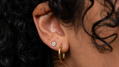 a close-up of a woman wearing gold hoop earrings