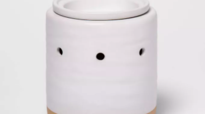 White candle holder with brown base and three holes around it