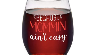 Glass of wine with text saying "because mommin' ain't easy"